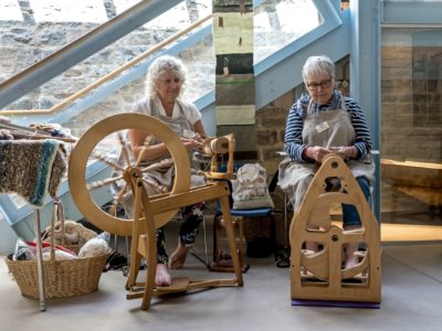 Two ladies with wooden yarn making machines