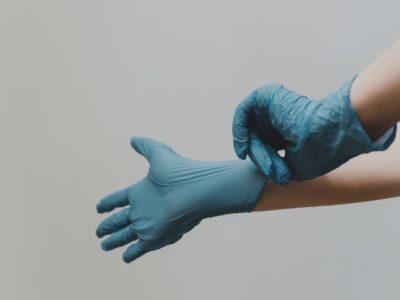 A pair of hands putting on some protective gloves