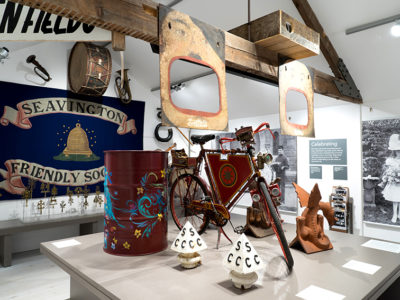 A flag, bike, barrel and a display of otherbjects at Somerset Rural Life Museum