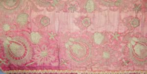 Pink patterned textile faded and structurally damaged by light 