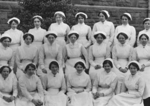 Black and white photo of three rows of Edwardian nurses posing for a photo.